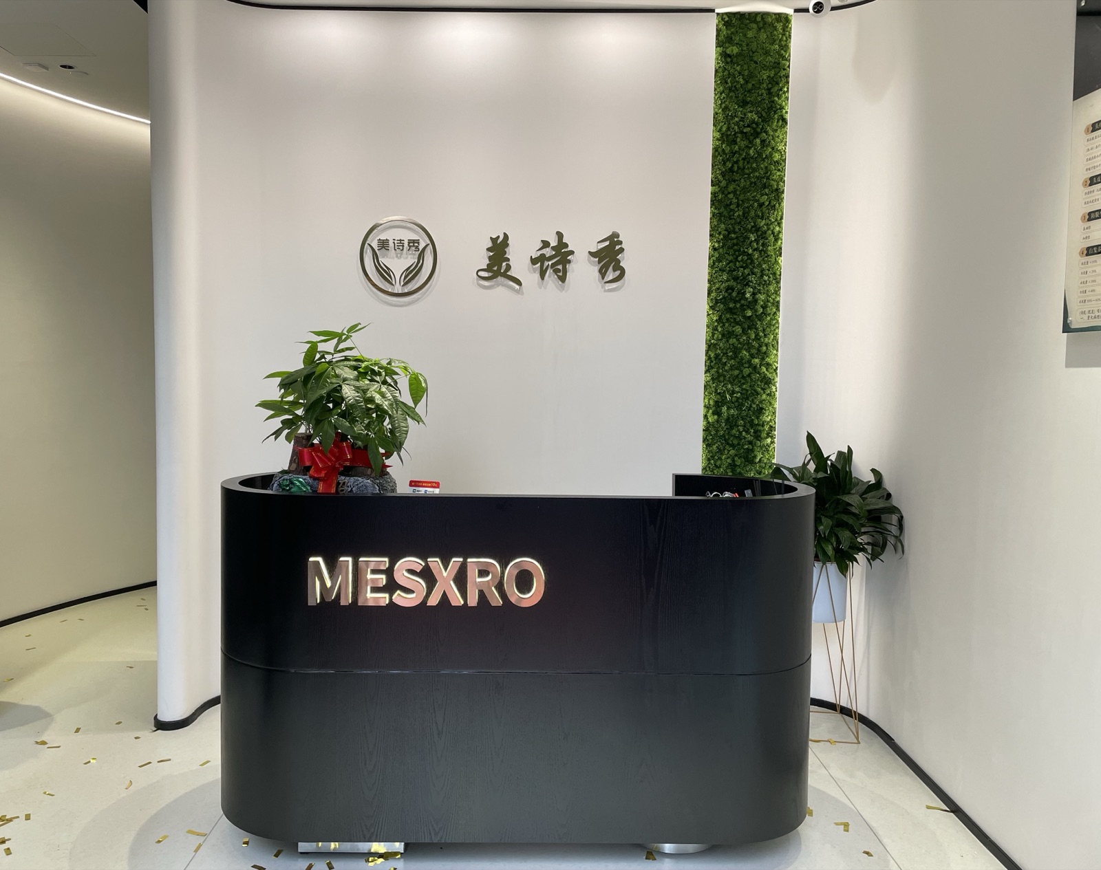 美诗秀前台形象墙,品牌标识 MESXRO 与美诗秀,旁侧为绿植墙 美诗秀前台形象墙,品牌标识 MESXRO 与美诗秀,旁侧为绿植墙